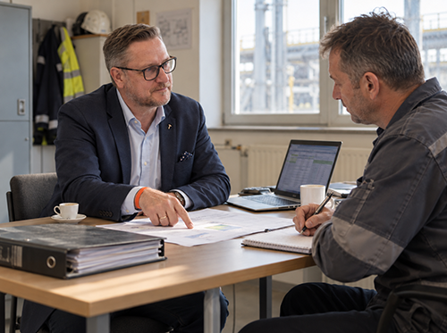 Erstgespräch am Tisch mit Betriebsleiter, Unterlagen liegen aus